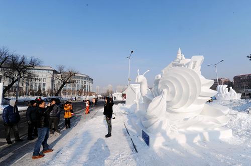 1月7日,几位参观者经过获得特等奖的哈尔滨理工大学学生的雪雕作品《灵梦之城》。新华社记者 王松 摄