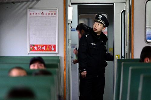 1月26日,乘警长张皓在7516次列车车厢内巡查。春节期间,沿途的群众经常随身携带一些易燃易爆物品,而沿途小站不具备安检条件,因此,车厢内的安检工作显得尤为重要。新华社记者 张锰 摄