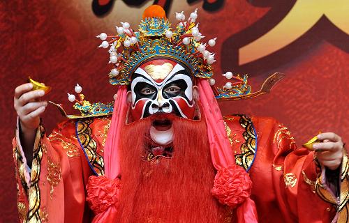2月1日,李永顺在长沙火宫殿古戏台上为市民表演《财神送福》。新华社记者 龙弘涛 摄