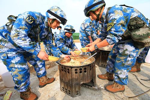 2月24日,海军陆战队官兵乘专列抵达北京军区某训练基地后进行野餐。新华社记者 查春明 摄