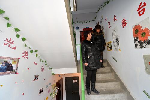 2月27日,两位居民在观看楼道内的才艺展示墙。新华社记者 陈斌 摄