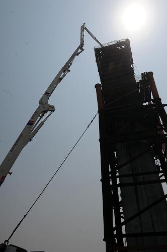 5月17日,工人用混凝土泵车对嘉绍跨海大桥北岸水中区最后一座桥墩进行浇筑。新华社记者 徐昱 摄