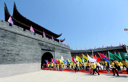 5月19日,中外大学生们一起从浙江宁海的西门古城门出发,参加庆祝“中国旅游日”的活动。当日是首个“中国旅游日”,作为徐霞客开游地的浙江省宁海县举行开游大典,中外游客齐聚宁海共同欢庆。398年前的5月19日是《徐霞客游记》的开篇日,这一天“游圣”徐霞客选择从宁海西门出发,开始了他一生“驰骛数万里,踯躅三十年”的游程;今年的4月中旬,国家旅游局宣布5月19日为中国旅游日,中国成为世界上少数设立国家旅游日的国家之一。新华社记者 徐昱 摄