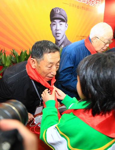 3月2日,在开幕式上少先队员为老摄影家季增(左)佩戴红领巾。新华社记者 查春明 摄