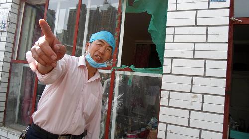 7月2日,内蒙古鄂尔多斯市东胜区建设街道办事处辖区灾民陈雪峰讲述暴雨洪水中越窗而出的逃生经历。新华社记者 张领 摄