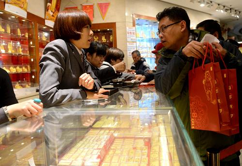 11月19日,消费者在菜百商场咨询马年贺岁金条。当日,由中国金币总公司发行的2014甲午(马)年贺岁金条在京上市。该套产品共有1000克、500克、200克、100克和50克5个规格,全国限量发行3.98吨,成色均为99.99%。金条采用浮雕、喷砂等工艺,金条正面加缀“甲午”纪念篆章,中间为“马年贺岁”四个书法大字;金条背面标有中国金币总公司标识和英文“CGCI”,每一款均配有中国金币总公司防伪鉴定证书。(新华社发)