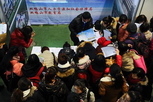 11月30日,求职者在一家用人单位展台前递交简历。新华社记者 许畅 摄