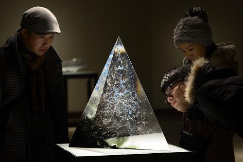 1月13日,在杭州中国美术学院美术馆,参观者在欣赏艺术家秦岭的锻造玻璃艺术作品《夏山》。新华社发(李忠 摄)