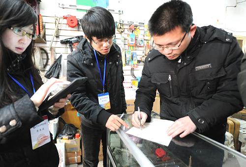 1月15日,一名个体户(右)积极配合工作人员填表做好普查工作。新华社记者 李晓果 摄
