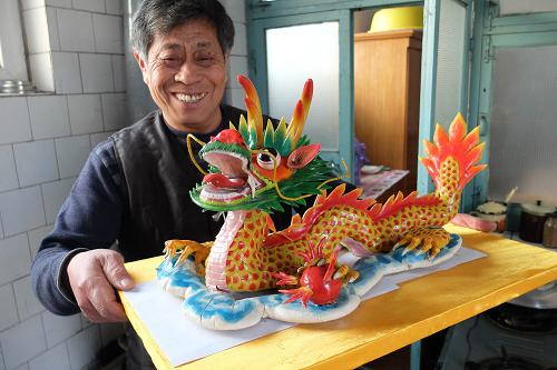 1月15日,山东省莱州市朱桥镇贾家村村民孙鸿令展示他制作的胶东花饽饽。新华社记者 徐速绘 摄