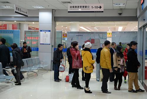 在广西东兴市出入境接待大厅,游客排队办理出境旅游手续(2月12日摄)。新华社记者 周华 摄