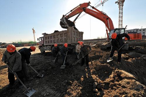 1月28日,农民工在北京地铁郭公庄车辆段工地施工。当日,中铁一局北京地铁郭公庄车辆段项目部组织人员将鱼肉、干果等年货和慰问品发放给春节期间坚守工地的农民工。为了保证北京地铁9号线按时开通,来自四川、河南、湖北等地的部分农民工放弃回家与亲人团聚的机会,坚持在工地上施工。新华社记者 何俊昌 摄