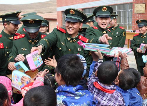 合作森林大队官兵在给孩子们分发文具(3月4日摄)。3月4日,武警甘肃陇南森林支队合作大队45名官兵,来到驻地南木娄藏族小学,为50名贫困学生赠送了书包、字典、铅笔等学习用品,并鼓励他们好好学习,长大后建设家园、报效国家。新华社发(冯子宣 摄)