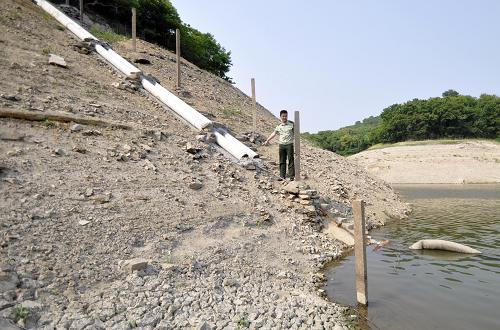 舟山市普陀区虾峙镇的虾峙水库干涸见底,自来水厂用于取水的管道已经高于水面,无法取水(5月31日摄)。新华社记者 徐昱 摄