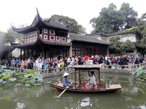 10月1日,演员在苏州古典园林留园的小船上为游人弹唱苏州评弹。新华社发(王建康 摄)