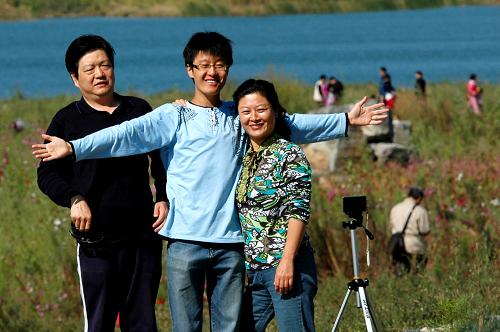 10月2日,市民在北京石景山区莲石湖畔拍摄合影。 新华社发(李文明 摄)
