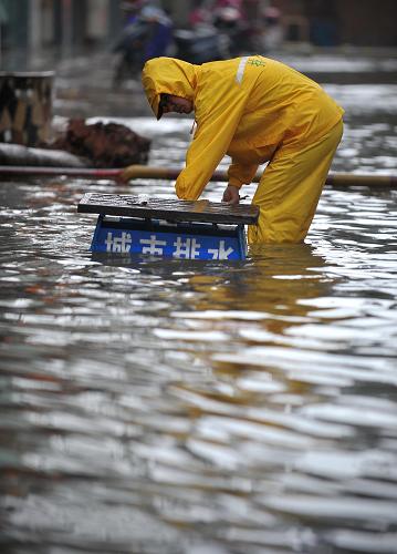 10月5日,海口市政工作人员在清理城市排水管道。强热带风暴“尼格”正逐渐远去,但海南暴雨仍在持续。受暴雨和海水倒灌影响,海口市多个路段积水严重,市内交通和市民生活受到严重影响。新华社记者 郭程 摄
