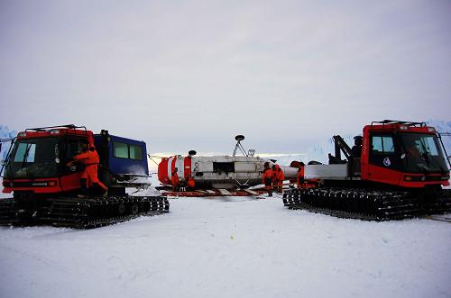 两辆PB240雪地车同时拖拽直升机损体(12月11日摄)。经过7个多小时的艰苦作业,第28次南极科考队当地时间11日3时10分左右(北京时间11日6时10分左右)终于将重约8.5吨(含1吨燃油)的“雪鹰”KA32直升机坠机损体拖拽至一个自制雪橇上,并成功运送到南极中山站等待后续处置。“雪鹰”直升机于当地时间8日晚9时20分左右在海冰区上空失控,实施迫降没有成功,造成飞机损坏。新华社记者 黄小希 摄