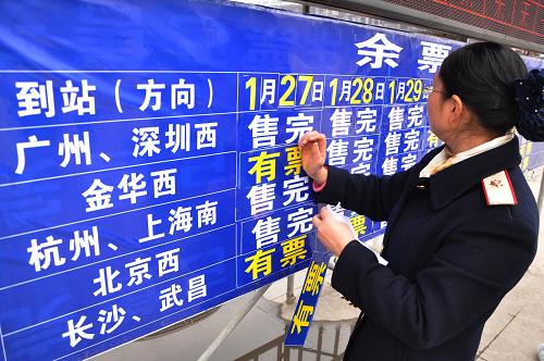 1月27日,怀化火车站工作人员在余票公告栏更换车票信息。新华社发(丁勇 摄)