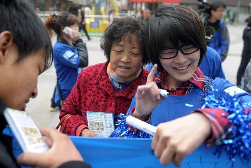4月2日,一名志愿者(右)向市民介绍自闭症。 当日是第五个世界自闭症日,来自兰州部分高校和从事自闭症关爱和照料的相关人士走上街头,向市民介绍自闭症,呼吁社会关注自闭症患者。 新华社记者 聂建江摄
