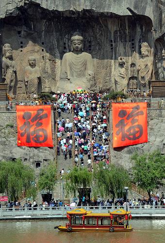 5月19日,大批游客沿石阶登上龙门石窟奉先寺景区参加祈福大法会。新华社记者 王颂 摄
