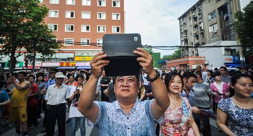 全国部分地区2012年高考结束 6月8日,在湖南长沙市一中考点,高考结束后,一名学生家长举起平板电脑拍照。 当日,全国部分地区2012年高考结束。2012年全国高考共有约915万名考生报名参加考试。 新华社记者白禹摄