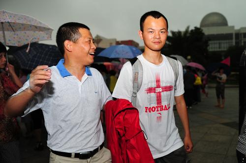 6月8日,在江西南昌二中考点,一名家长听儿子说考得不错很高兴。 当日,全国部分地区2012年高考结束。2012年全国高考共有约915万名考生报名参加考试。 新华社记者周科摄