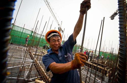 6月20日,一名建设者在10层高的操作面加固钢筋。新华社记者 岳月伟 摄