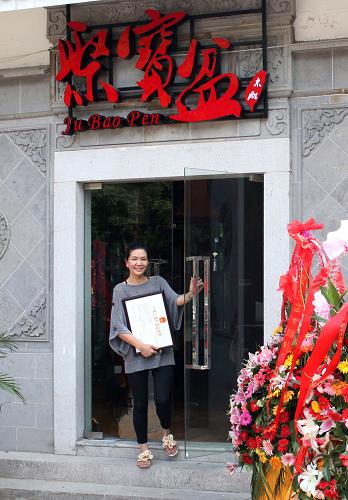 6月21日,店主陈金卿站在她新开张的店铺门前。新华社发(丁焕新 摄)