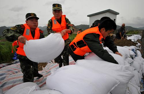 8月7日,浙江三门边防官兵搬运沙袋,增高加固海塘坝。据浙江气象台发布最新消息,“海葵”7日下午加强为强台风,其中心位于台州东南偏东方向约280公里的海面上,近中心最大风力14级。受此影响,浙江省多地出现强降雨,部分水库超汛限水位,防洪形势严峻。新华社发(郏策 摄)
