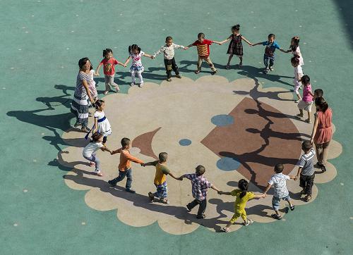8月24日,幼儿园大四班的同学和老师在操场上玩耍。米脂县位于陕西省榆林市,人均年收入仅6704元,贫困人口有5万多人,是国家级贫困县。然而,就在米脂县城,390名孩子在投资1500余万元的“豪华”幼儿园内健康、快乐地学习成长。据悉,这是米脂县的教育利民工程,由县政府投入一千余万元,榆林市和社会捐款500万元,于2011年9月份共同修建完成,园内音乐室、美术室、舞蹈室等教育设施一应俱全。新华社记者 陈诚 摄