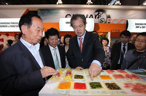 10月21日,中国驻法国大使孔泉(中)在2012法国国际食品展上参观中国展台。新华社记者 高静 摄