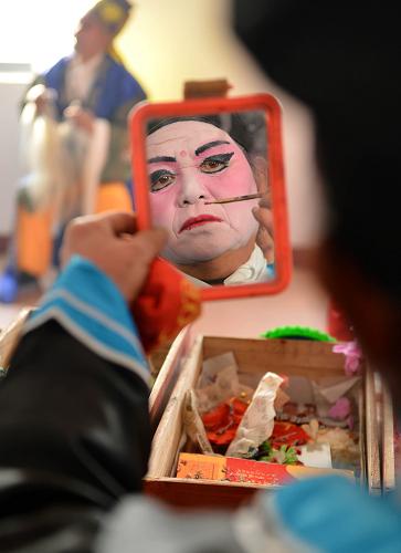 “庄户剧团”乐乡村 11月24日,村民演员在演出前化装。 农忙已过,山东邹平县西黄村的“庄户剧团”又开始忙碌起来,十里八乡的村庄都纷纷邀请她们去演出。西黄村业余剧团1998年正式成立,由村民们自发、自愿结合,不计任何报酬。十几年来,业余剧团的演职人员不断变化,但为村民义务演出的传统和对民间戏曲的喜爱一直没改变。现在,西黄村业余剧团的成员们已经整理、编排传统剧目37出,每年为村民演出40余场次。 据山东省文化部门统计,山东目前有农村民办剧团5200个,这些“庄户剧团”根植乡村大地,丰富繁荣了农村文化生活。 新华社记者 朱峥摄