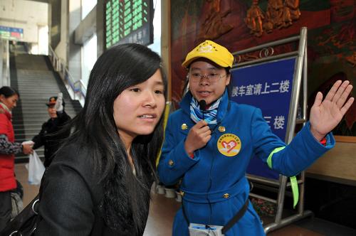 图为2011年2月10日,志愿者王琴晏(右)在贵阳火车站候车厅内引导旅客。 新华社记者 刘续 摄