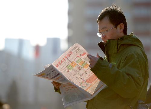 2月23日,求职者在招聘现场外阅读现场发放的招聘信息。新华社记者 罗晓光 摄