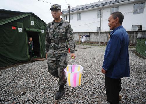 一名战士在为孤寡老人打水(5月16日摄)。新华社记者 李晓果 摄