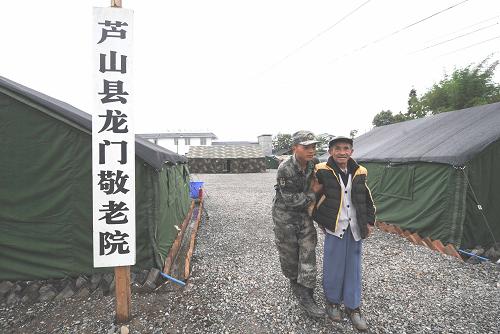 一名战士搀扶行动不便的老人(5月16日摄)。新华社记者 李晓果 摄