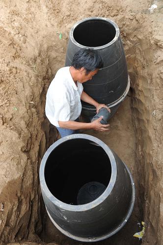 6月14日,在河北省内丘县金店镇大辛旺村,村民正在安装“双瓮漏斗式厕所”。 自2011年以来,河北省内丘县在全县平原区5个乡镇、3.6万户农户中推广“双瓮漏斗式厕所”。这种厕所由漏斗形蹲便器、前后两个瓮式储粪池、连通管、后宽盖和厕室组成。“双瓮”一前一后埋入地下,前瓮连着蹲便器口,后瓮用盖密封,前高后低,中间相互连通。瓮储满后掀开密封盖,抽出来的发酵粪便还可做肥料。 “双瓮漏斗式厕所”不仅占地面积小,还方便卫生,一改传统旱厕“晴天臭烘烘,雨天粪水流”的脏乱差面貌。目前,内丘县已经完成改建“双瓮漏斗式”厕所近万个。 新华社记者王民摄