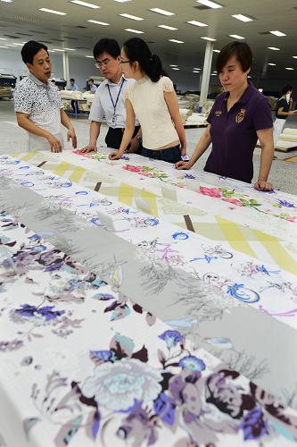 参观者在山东魏桥创业集团参观企业生产的新型纺织产品(6月26日摄)。 近年来,位于山东省邹平县的世界最大棉纺织企业——魏桥创业集团在企业发展中以市场需求为导向,依靠集团的技术团队不断进行技术创新,相继自主研发并批量生产具有抗菌、阻燃、免烫、防紫外线等特点的有机棉、超爽纤维、大豆蛋白纤维、牛奶纤维、竹纤维等新型功能性纤维及高支特细纱和高支高密坯布品种,填补了多项国内空白,提升了产品在国内外市场的竞争力。 新华社发(董乃德 摄)