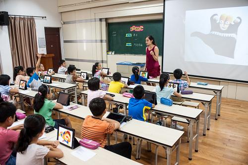 9月11日,在常州市局前街小学,美术老师杨茵雯利用平板电脑为四年级的学生讲授创意课程《会说话的手》。为进一步推进教育信息化,促进中小学教育教学模式和学习方式的转变,江苏省于2012年启动了基础教育百校数字化学习(简称“e学习”)试点工作,在课程、教材、教学、评价、管理等五个领域推行信息化改革和创新。在常州市局前街小学和觅渡桥小学,信息化网络已经在改变传统课堂形态:学生可以通过平板电脑或触屏电脑完成老师布置的任务并提交到班级网络,同学之间可以互相查看各自的习题解法或美术作品并做出修改和评价,老师也能及时点评课堂作业;学有余力的学生可以挑战难题,而对于学习有困难的学生,系统也能提供详尽的提示,同学间也能很方便地互相帮助。新华社记者 李芒茫 摄
