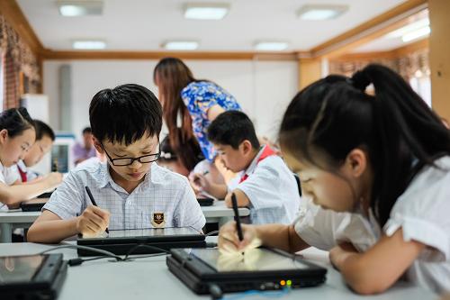 9月11日,常州市觅渡桥小学五(3)班学生在数学课上使用触屏电脑和教学网络完成习题。新华社记者 李芒茫 摄