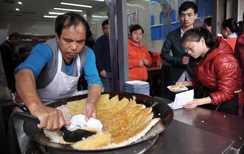 长沙坡子街一家小吃店的工作人员正在制作长沙当地小吃——长沙豆皮(2月2日摄)。 新华社记者 李尕 摄