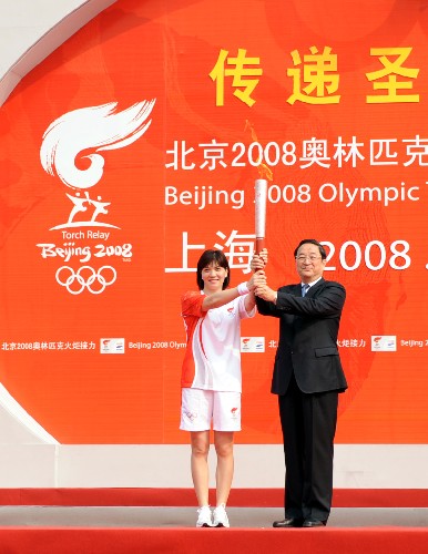 5月23日,中共中央政治局委员、上海市委书记俞正声(右)与上海第一棒火炬手庄泳共同展示火炬。当日,北京奥运会圣火在上海传递。 新华社记者刘力航摄