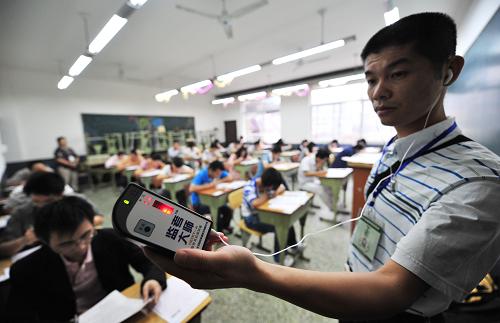 9月19日,在成都职业技术学院青羊校区考点,监考老师用隐形耳机探测器防止考生作弊。当日,为期两天的2009年国家司法考试在全国统一开考,全国报名人数超过41万,再创历史新高,比去年增加3万余人。这是我国统一司法考试制度实施以来举行的第8次考试。新华社记者 江宏景摄