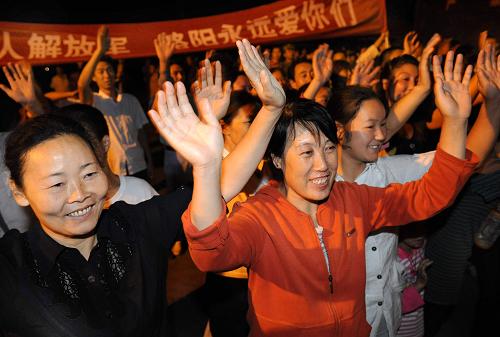8月12日,前来送行的人向解放军挥手告别。当日,从地震灾区陕西省略阳县撤离的解放军驻陕某工兵团官兵,从横现河火车站启程,略阳县上千名群众自发到车站送别亲人子弟兵。 新华社记者 陶明 摄