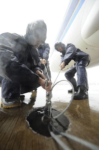 9月29日,在海口市美兰机场,工作人员固定未离港飞机为台风“纳沙”登陆做准备。