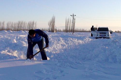 1月21日,过往群众正在清理道路积雪。新华社记者 关俏俏 摄