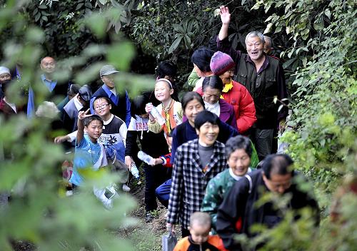 10月16日,湖北宣恩县参加重阳登高的人们在林间小道上行进。 新华社发(宋文 摄)