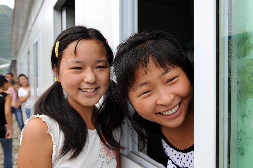 8月21日,青川县木鱼中学的学生在活动板房宿舍活动。“5·12”大地震使四川省青川县所有的中小学校受损,学生全部被迫停课。3个多月以来,在全国人民的爱心帮助下,有关单位组建了专门的建筑队伍,共搭建学校用临时活动板房12万平方米,新添置课桌凳3.2万套。自8月1日起,青川县59所中小学全面复课,灾区3.8万名孩子重新走进校园。 新华社记者 陶明 摄