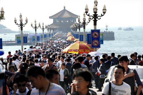 10月2日,游客在青岛栈桥景区游览。“十一”黄金周期间,在“帆船之都”后奥运效应和啤酒节的双重拉动下,山东青岛市迎来旅游客流新高峰,各大景区接待游客人数与2007年同期相比增长了约25%。据青岛市假日办统计,国庆节当天包括崂山风景区、海滨风景区、极地海洋世界、奥帆中心等在内的前海六个景区(点)共迎来游客35.53万人次,创下“十一”黄金周青岛接待客流新纪录。 新华社记者 李紫恒 摄